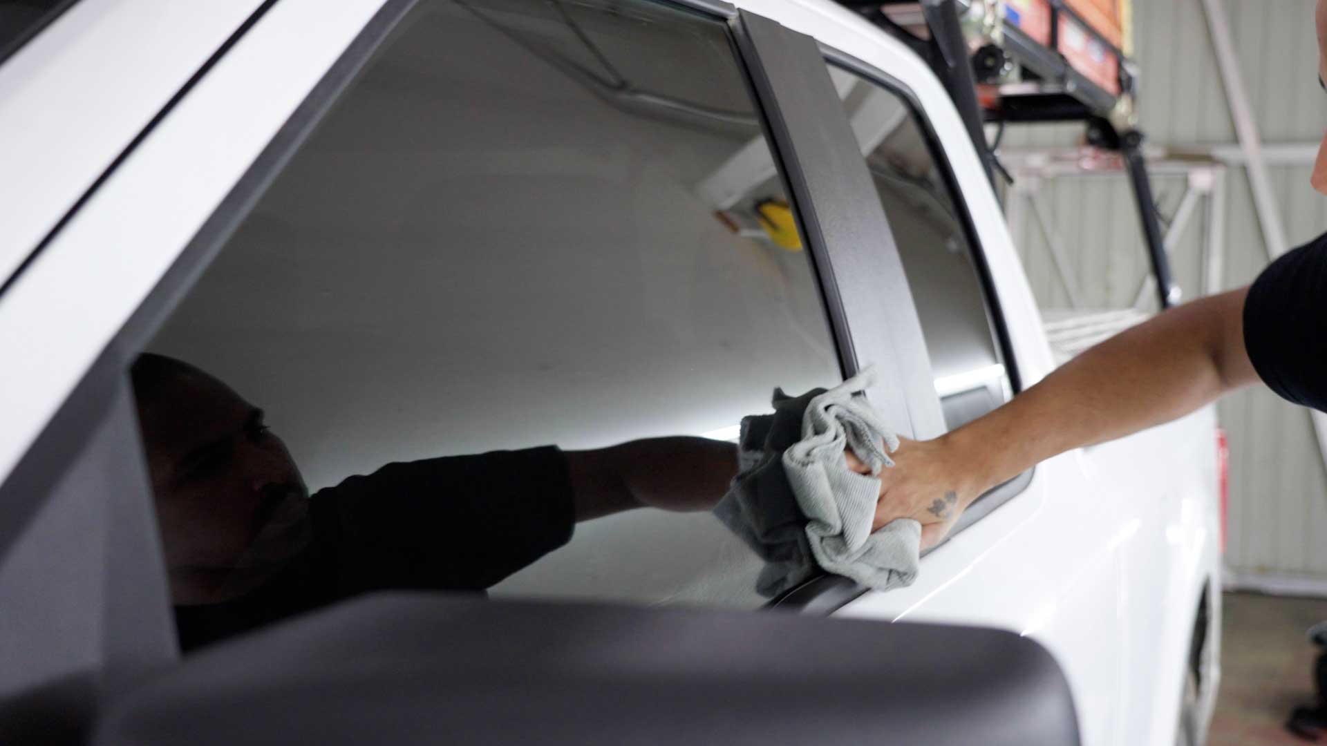 Skilled Vehicle Window Tint being cleaned after tinting in Lima