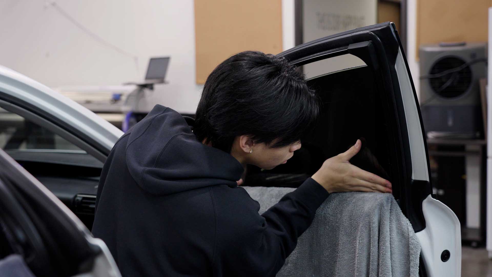 Technician installing ceramic window film on a car in DE
