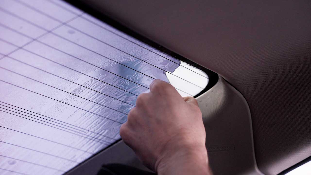 Professional removing window film to comply with DE tint laws